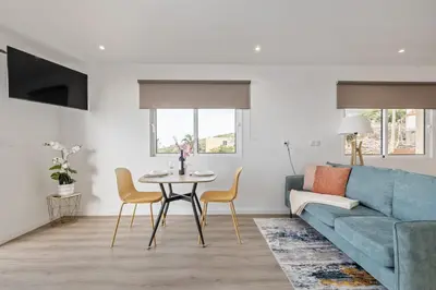 a living room with a blue couch and a table at Casa Avô ladeira 2 in Estreito da Calheta