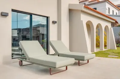 two lounge chairs on a patio with windows at Casa Modelo in Funchal