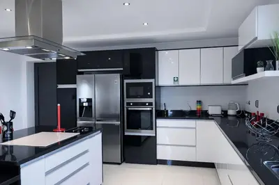 a kitchen with white cabinets and black appliances at Villa Vieira Ocean View in Gaula