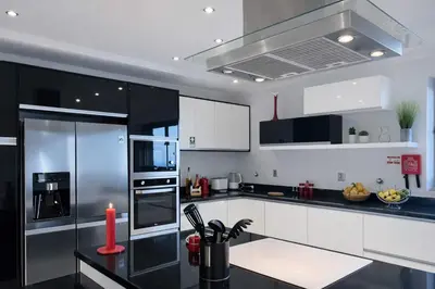 a kitchen with white cabinets and a black counter top at Villa Vieira Ocean View in Gaula