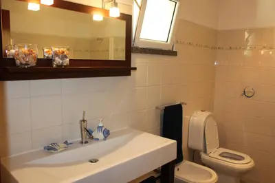 a bathroom with a sink and a toilet and a mirror at Apartment Villa Sol II in Ponta do Sol