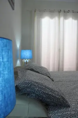 a bedroom with a bed with a blanket and a lamp at Apartment Villa Sol II in Ponta do Sol