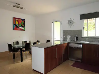 a kitchen with a counter and a table with chairs at Apartment Villa Sol II in Ponta do Sol