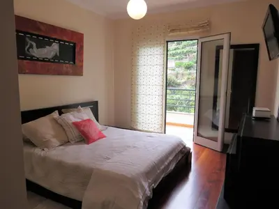 a bedroom with a bed and a sliding glass door at Apartment Villa Sol II in Ponta do Sol
