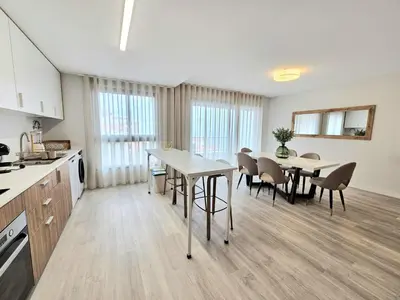 a kitchen and dining room with a table and chairs at Garajau Palace Sea View I in Caniço
