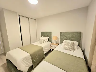 a bedroom with two beds and a window at Garajau Palace Sea View I in Caniço