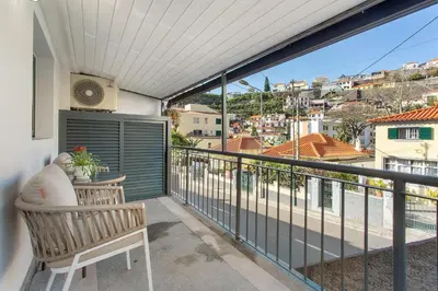 a balcony with a table and a view of the city at Idalina's Place Funchal in Funchal
