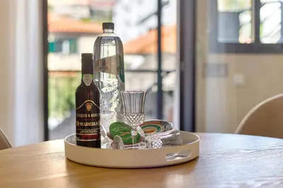 a bottle of wine and a glass on a table at Idalina's Place Funchal in Funchal