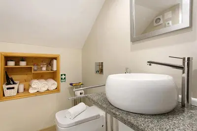a bathroom with a white sink and a toilet at Idalina's Place Funchal in Funchal