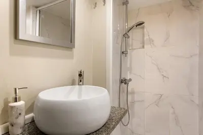 a white bathroom with a sink and a shower at Idalina's Place Funchal in Funchal