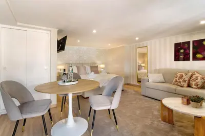 a living room with a bed and a table and chairs at Idalina's Place Funchal in Funchal