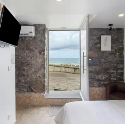 a bedroom with a bed and a view of the ocean at Casa Dos Avós - Sea View Studio in São Vicente