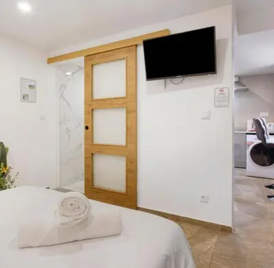 a room with a door and a television on a wall at Casa Dos Avós - Sea View Studio in São Vicente