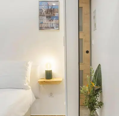 a bedroom with a bed and a table next to a door at Casa Dos Avós - Sea View Studio in São Vicente