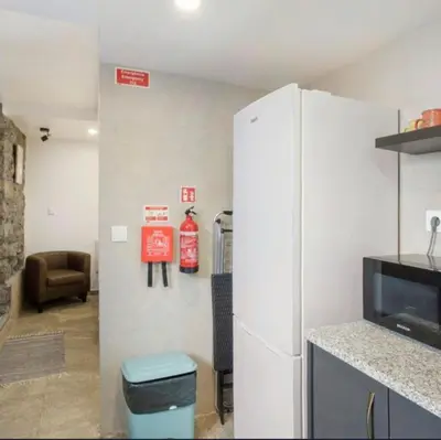 a kitchen with a white refrigerator and a living room at Casa Dos Avós - Sea View Studio in São Vicente