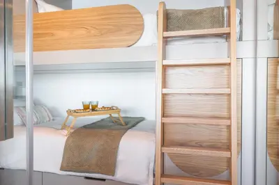 a bedroom with two bunk beds and a table at Big Cliff - Ocean View by AH in Câmara de Lobos