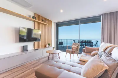 a living room with a couch and a television at Big Cliff - Ocean View by AH in Câmara de Lobos