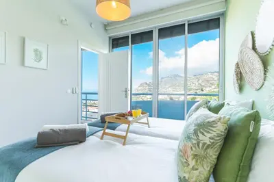 a bedroom with a bed with a view of the ocean at Pitanga Apartment by AH in Câmara de Lobos