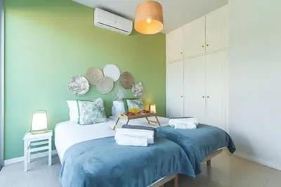 a bedroom with two beds with blue sheets at Pitanga Apartment by AH in Câmara de Lobos