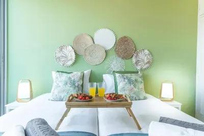 a bed with a tray of fruit and glasses of orange juice at Pitanga Apartment by AH in Câmara de Lobos