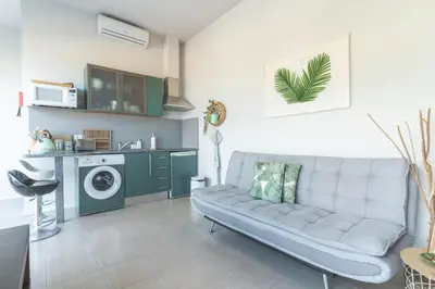 a living room with a couch and a washing machine at Pitanga Apartment by AH in Câmara de Lobos