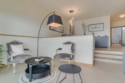 a living room with two chairs and a table at Bay Bliss - Ocean & City View by AH in São Gonçalo