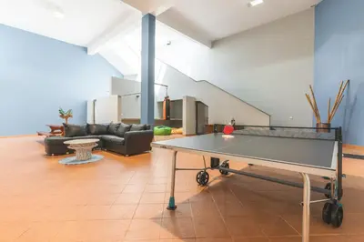 a ping pong table in the middle of a living room at Bay Bliss - Ocean & City View by AH in São Gonçalo
