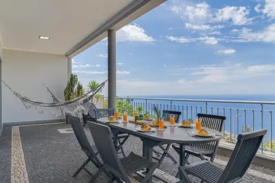 a table on a balcony with a view of the ocean at Bay Bliss - Ocean & City View by AH in São Gonçalo