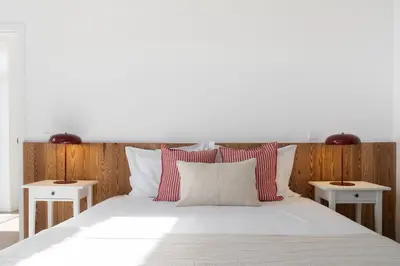 a bed with red and white pillows and two tables at Traditional House Cozy 3-bedroom house in Funchal