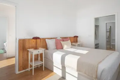 a bedroom with a white bed with a wooden headboard at Traditional House Cozy 3-bedroom house in Funchal