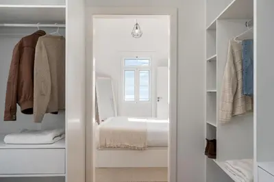 a white room with a bed and a closet at Traditional House Cozy 3-bedroom house in Funchal