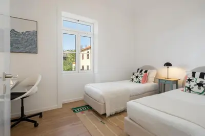 a bedroom with two beds and a desk and a window at Traditional House Cozy 3-bedroom house in Funchal