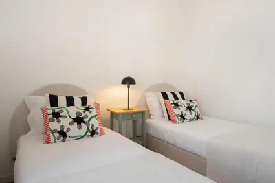 two twin beds in a room with a table at Traditional House Cozy 3-bedroom house in Funchal