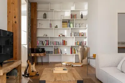 a living room with white shelves with books at Traditional House Cozy 3-bedroom house in Funchal