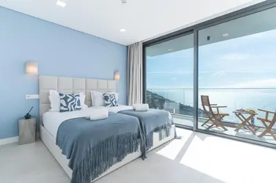 a bedroom with a bed and a large window at Villa Devaneio - Amazing Ocean View by Atlantic Holiday in Ribeira Brava
