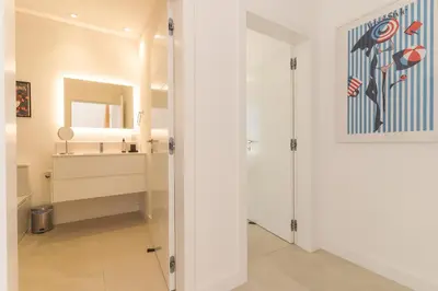 a hallway with a bathroom with a sink and a mirror at Villa Devaneio - Amazing Ocean View by Atlantic Holiday in Ribeira Brava