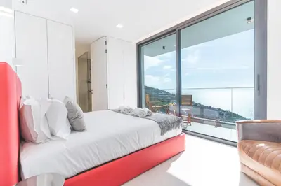a bedroom with a bed and a large window at Villa Devaneio - Amazing Ocean View by Atlantic Holiday in Ribeira Brava