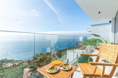 a balcony with a table and a view of the ocean at Villa Devaneio - Amazing Ocean View by Atlantic Holiday in Ribeira Brava