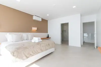 a white bedroom with a large bed with white pillows at Villa Devaneio - Amazing Ocean View by Atlantic Holiday in Ribeira Brava