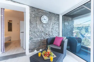 a bedroom with a bed and a stone wall at A Casinha by Atlantic Holiday in Câmara de Lobos