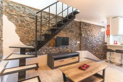 a living room with a couch and a staircase at A Casinha by Atlantic Holiday in Câmara de Lobos