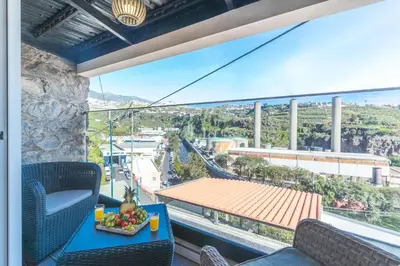 a balcony with a table with a bowl of fruit on it at A Casinha by Atlantic Holiday in Câmara de Lobos