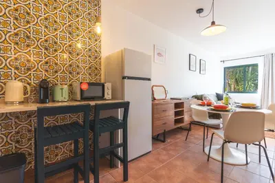 a kitchen with a counter and a table and a refrigerator at Richelieu Apartment by Atlantic Holiday in Água de Pena