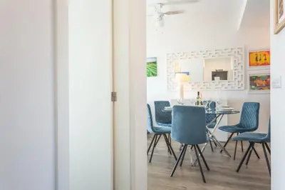 a dining room with blue chairs and a table at Aqui ha Casa - Ocean View by Atlantic Holiday in Gaula