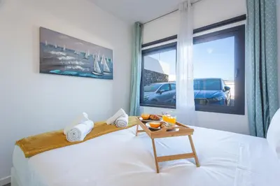 a bedroom with a bed with a tray of food on it at Aqui ha Casa - Ocean View by Atlantic Holiday in Gaula