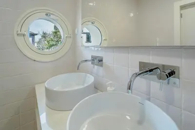 a white bathroom with a sink and a mirror at Casa da Levada in Funchal