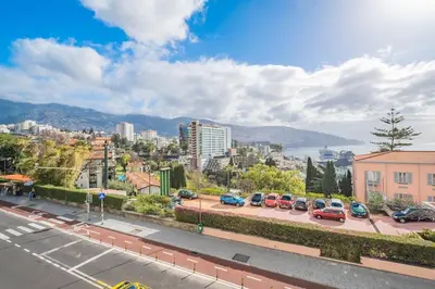 a city with cars parked in a parking lot at Sea View 1 Bedroom Apartment Funchal in Funchal