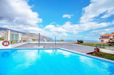 a swimming pool on the roof of a building at Sea View 1 Bedroom Apartment Funchal in Funchal