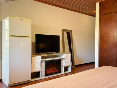 a living room with a tv and a fireplace at Habitación con Cocina en la Montaña in Funchal