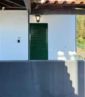 a green door on the side of a building at Habitación con Cocina en la Montaña in Funchal